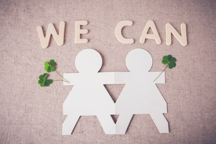 paper dolls holding hands with green leaves and 'WE CAN' word