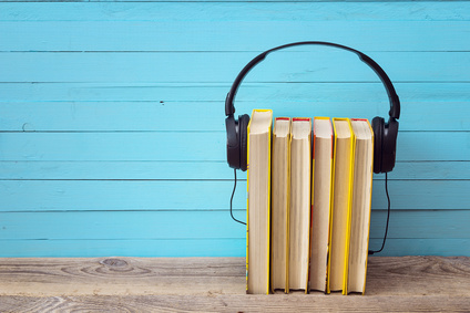 Audio book concept, yellow books and headphones over blue backgr