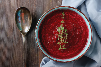 Traditional beetroot soup in a blue plate with Temyan. Dark wood background. Light fabric. free space text. Top view.