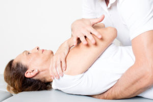 physiotherapy doctor applying a body manipulation on a female patient