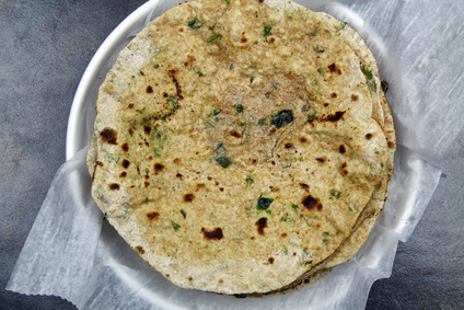 Overhead view of a stack of whole wheat and chopped spinach leaves Chapati or Roti or Tortilla