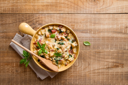 Baked bread pudding with ham, spinach and cheese, vertical view from above, selective focus