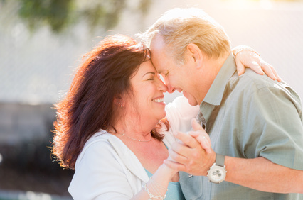 Happy Middle Aged Couple Enjoy A Romantic Slow Dance Outside.