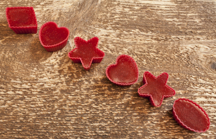 Red marmalade in molds on wooden background