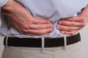 Close up of business man holding his lower back. Man rubbing his painful back