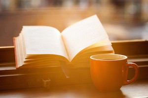 Books and a coffee cup on a windowsill