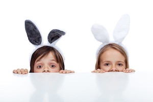 Kids with bunny ears peeking from beneath the table - waiting for the easter rabbit