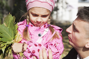young father calms little daughter in the park
