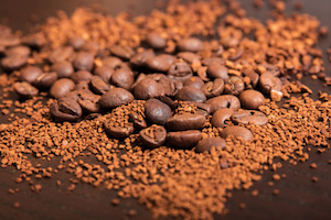 Coffee beans and cinnamon on a dark brown table with a space for text