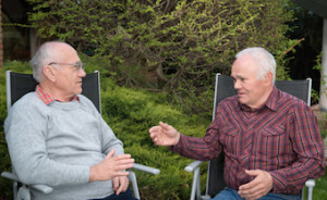 two senior men sitting in garden and descussing