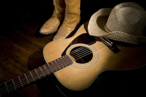 Spotlight on country guitar, boots and hat