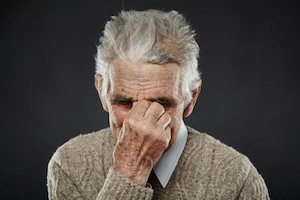 Elderly caucasian man with a strong migraine isolated on white