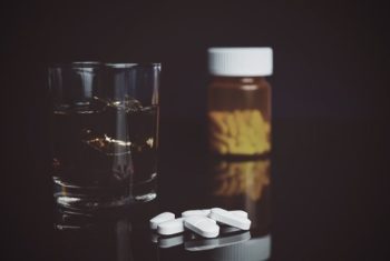 drugabuse-shutterstock248285614-alcohol-on-table-with-pills-feature-image-cocurrent-alcohol-painkillers