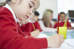 Female Elementary Pupil Working At Desk