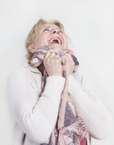 eine ältere Frau mit blonden Haaren ist glücklich und schaut nach oben