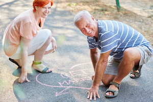 Senioren malen Herz mit "Get Married" Text auf den Boden