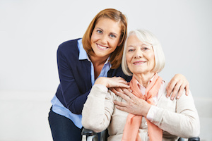 Lächelnde Frau bei der Altenpflege im Seniorenheim mit einer Seniorin