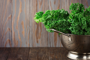 Fresh Green Kale leaves on rustic wooden background, selective focus