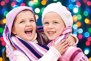 Cute little girls hugging and laughing together on Christmas Eve