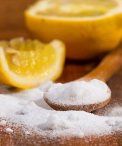 baking soda (sodium bicarbonate) in a wooden spoon and lemon