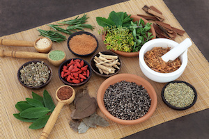 Herb and spice selection used in herbal health for men on bamboo mat.