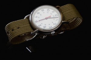 Military style watch on black reflective background