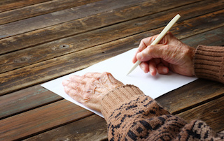 close up of elderly male hands on wooden table