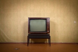 Retro TV on a background of vintage wallpaper in old room with vignetting