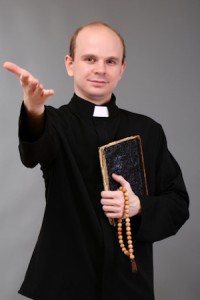 Young pastor with rosary and Bible, on gray background