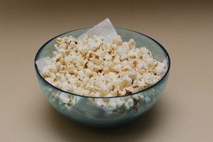 Homemade popcorn in a glass bowl on an oil obsreving tissue paper