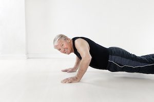 side view of senior man doing push-ups
