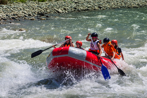 A GROUP OF MEN AND WOMEN, WITH A GUIDE, WHITEWATER RAFTING ON THE PATATE RIVER, ECUADOR