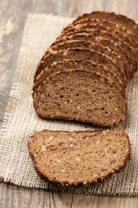 Sliced rye bread with seeds on a wooden table