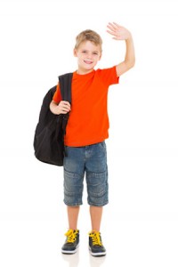 smiling schoolboy with backpack waving goodbye