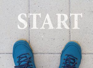Shoes before the word Start. Blue shoes on the sidewalk in front of Straton, the beginning.
