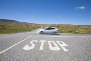 crossroads with stop symbol white painted on asphalt and fast car in rural road next to Madrid Spain Europe