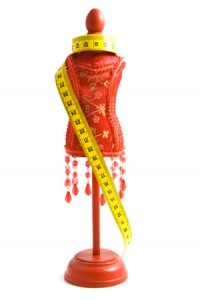 A tailor's dummy with measuring tape isolated over white