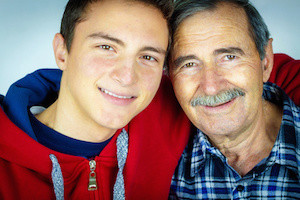 Grandfather and grandson. Teenage boy hugging grandfather