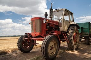old tractor on the field, against a cloudy sky