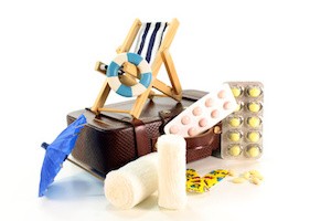 Medikamente und Koffer vor weißem Hintergrund