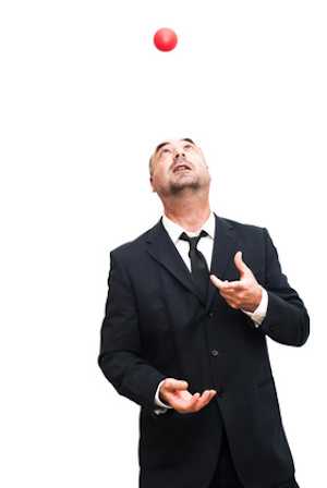 Businessman that is juggling with a red balls over white